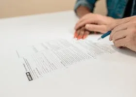 pexels-photo-7979428-7979428-1 Close-up of hands signing adoption papers in an office environment, symbolizing family and legal process.